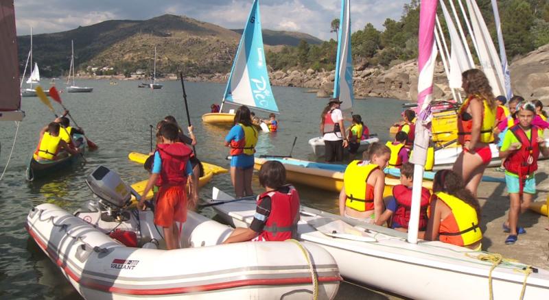 Grupo de jóvenes montándose en las barcas y los kayaks preparados para la regata final del campamento de verano