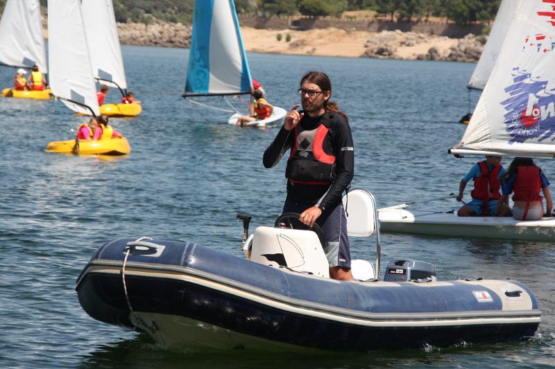 Monitor controlando desde la zodiac a los jóvenes en sus velas durante las sesiones del campamento vela