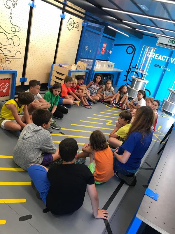Niños atendiendo a su monitora durante un campamento lugo