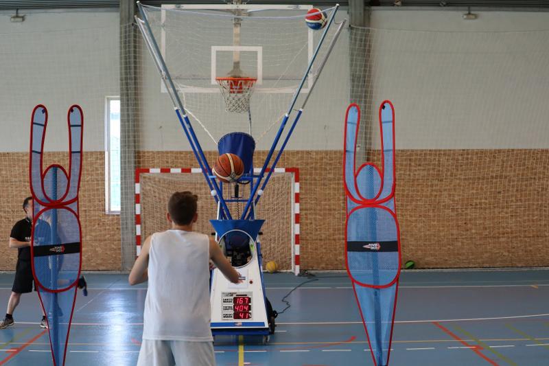 Niño entrenando su tiro durante un campamento de baloncesto