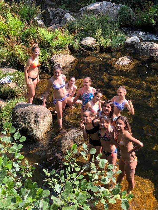 Niñas disfrutando de un baño en el río durante un campamento de verano galicia