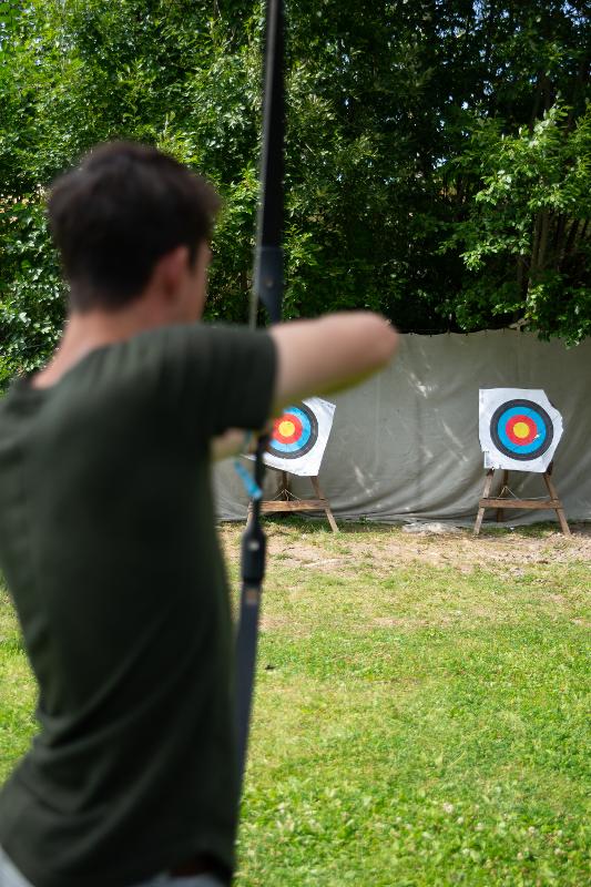 Chico haciendo tiro con arco en el campamento de verano en suecia