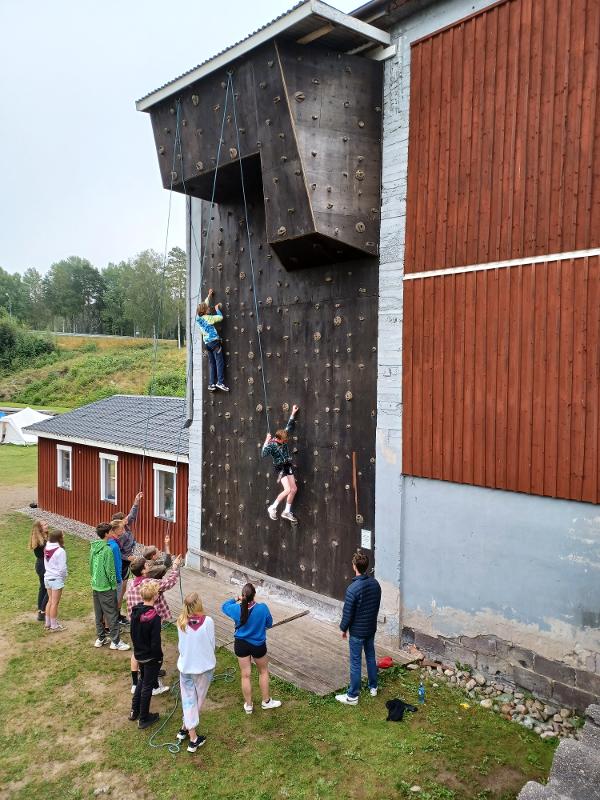 Jóvenes subiendo a un rocódromo en el campamento de verano en suecia
