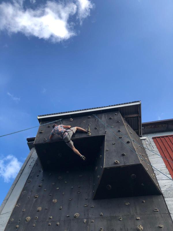 Joven trepando un rocódromo campamento de verano en suecia