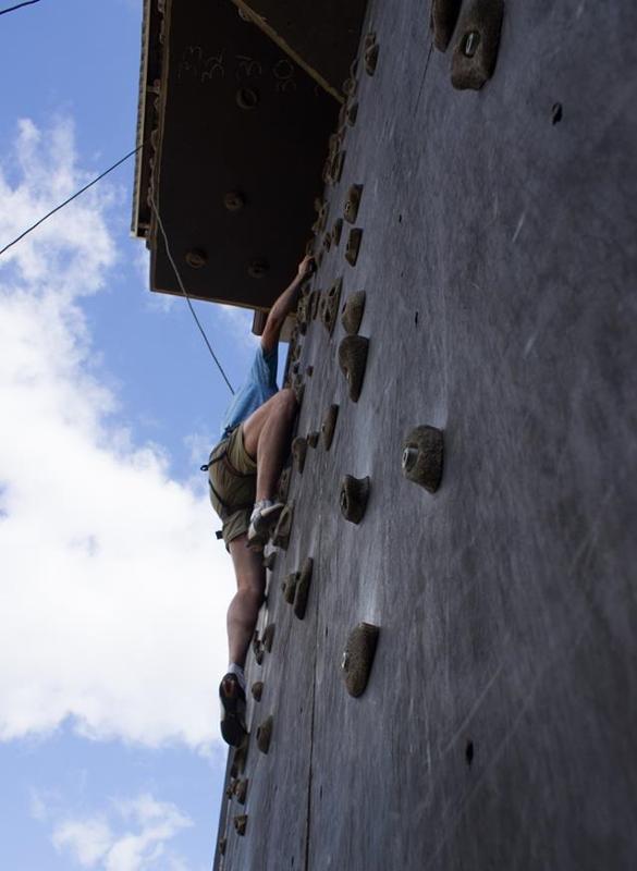 Chico subiendo a un rocódromo en el campamento de verano en suecia