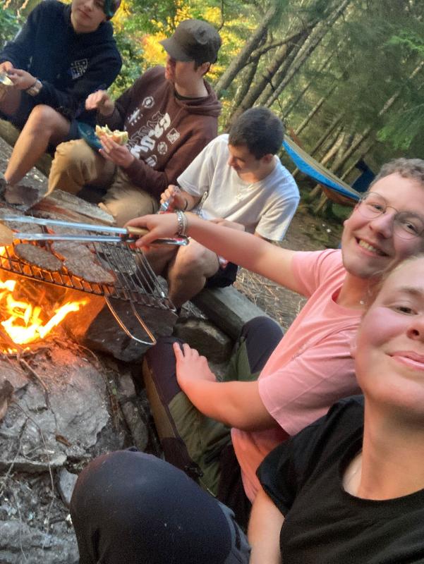 Selfie de jóvenes cocinando hamburguesas en una barbacoa en el campamento de verano en suecia