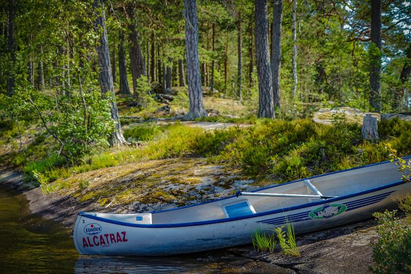 Canoa atracada en la orilla del río en el campamento de verano en suecia