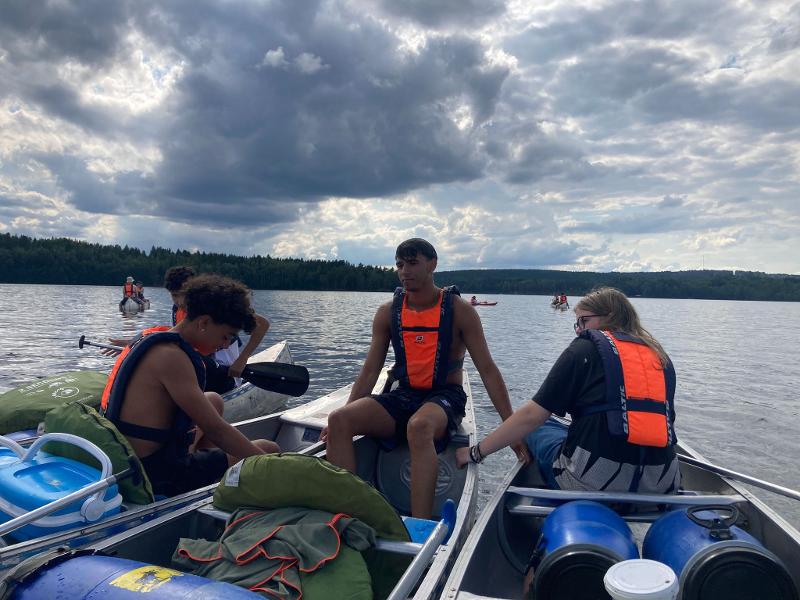 Jóvenes descansando en las canoas en el campamento de verano en suecia
