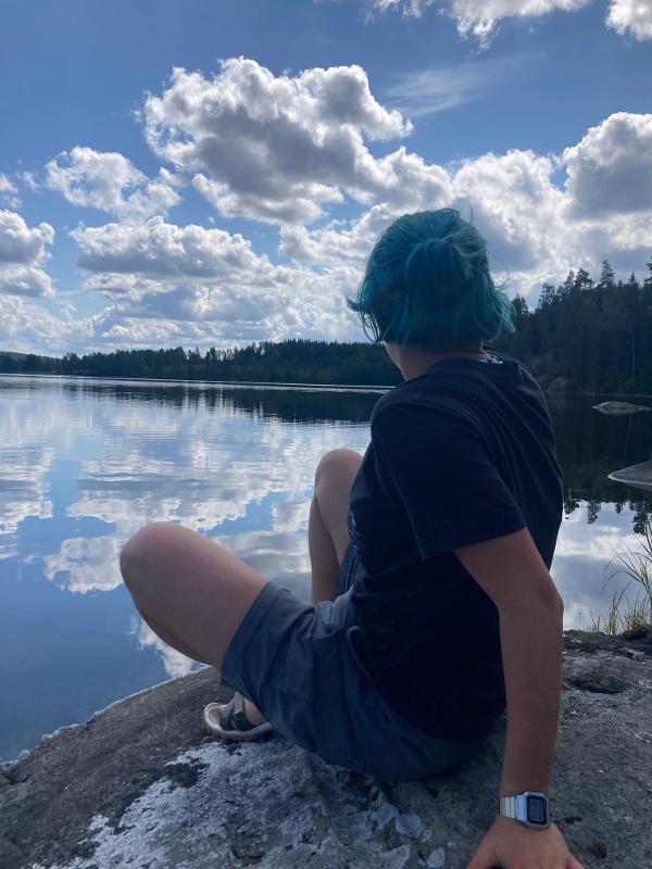 Joven posando delante del lago en el campamento de verano en Suecia