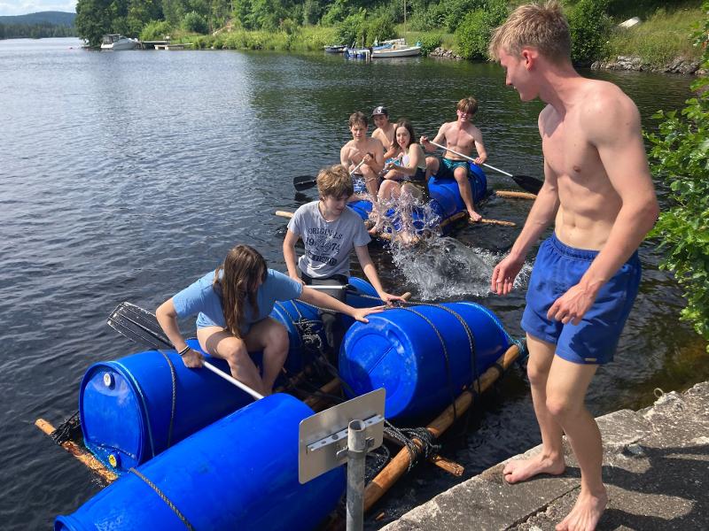 Jóvenes sentados en canoas de materiales reciclados en el campamento de verano en Suecia
