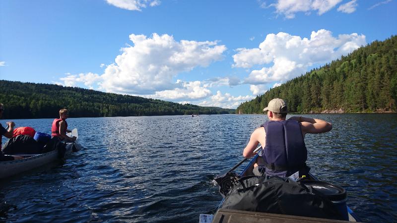Jóvenes en canoa en el agua en el campamento de verano en Suecia