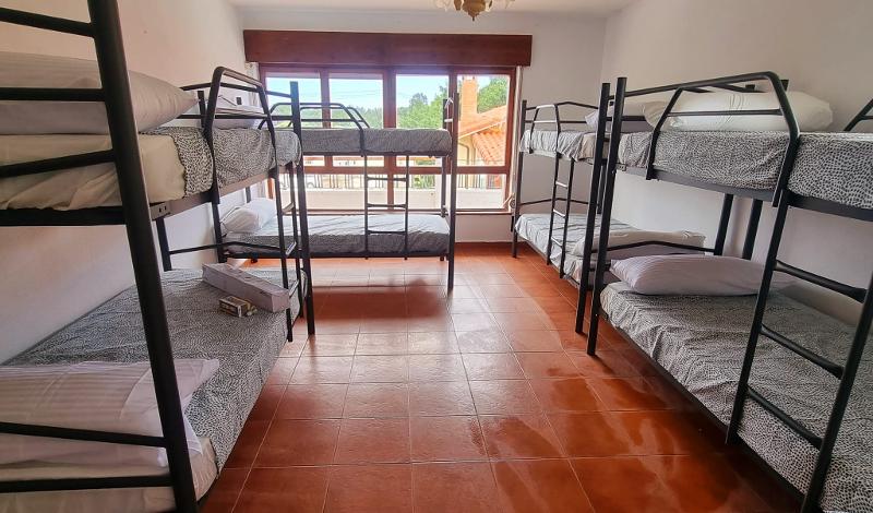 Habitación con gran ventanal y cuatro literas en el campamento verano asturias