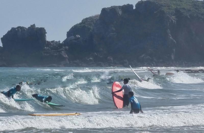 Niños dirigiéndose hacia el mar para saltar las olas durante un surfcamp asturias