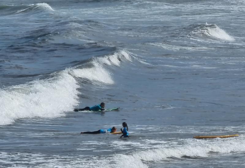Niños en plancha sobre la tabla en una clase del surf camp en asturias