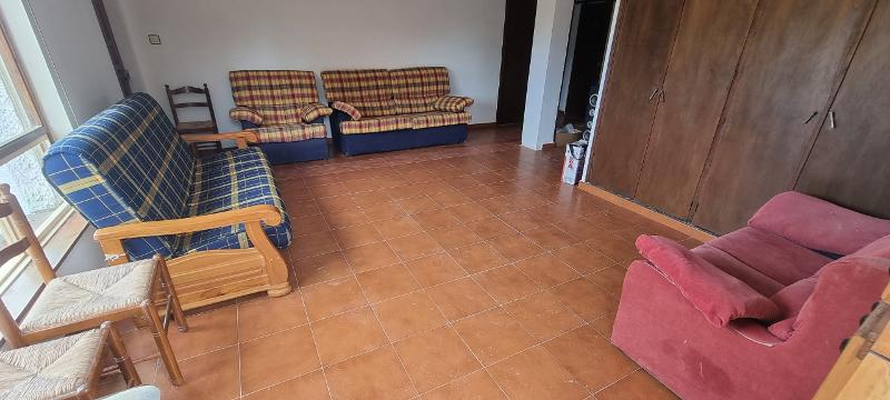 Amplia sala común con sofás en un surf camp en asturias