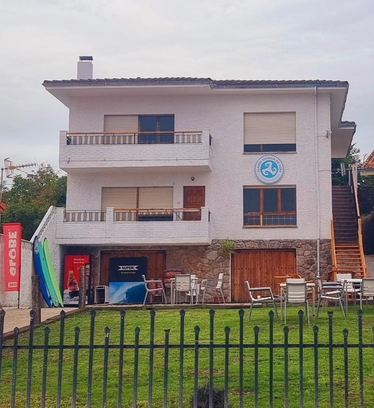 Edificio de instalaciones con jardín de un surfcamp asturias