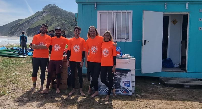 Monitores de un campamento de verano asturias posando para una foto junto a una caseta