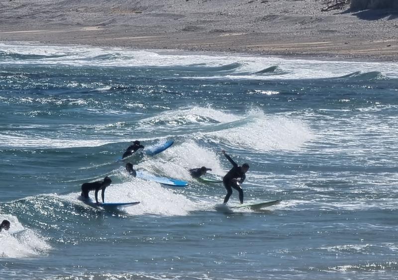 Adolescentes surfeando las olas durante un surf camp en asturias