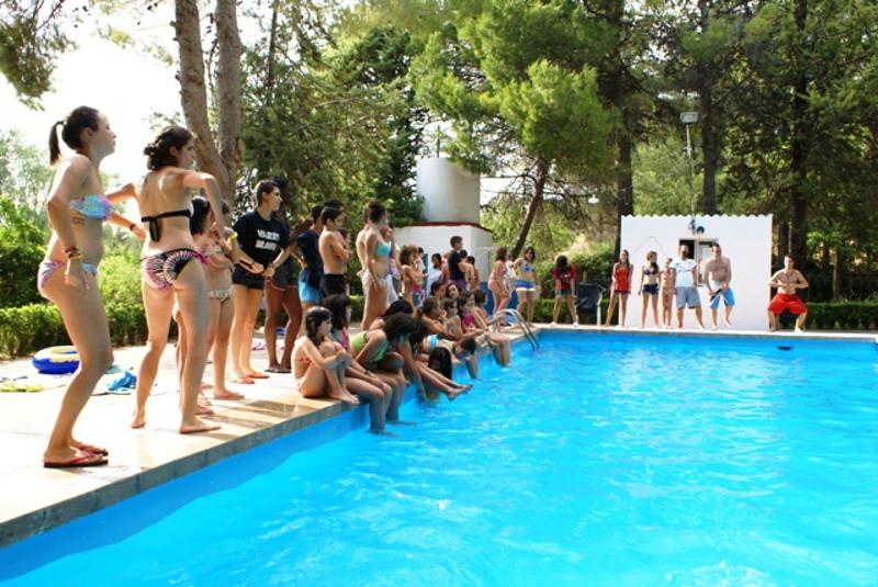Grupo de participantes adolescentes preparados para jugar un partido en la piscina en el campamento de waterpolo