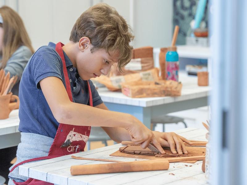 Niño realizando manualidades y actividades con cerámica durante un campamento en burgos