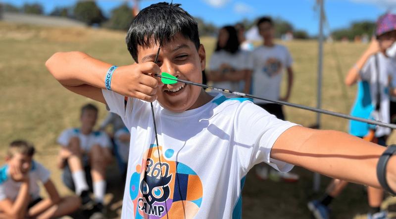 Un niño practicando tiro con arco en un campamento de verano para niños en leon