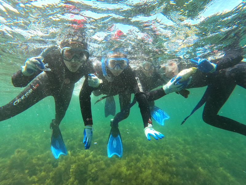 Chicos buceando con la equipación de buceo en la colonia náutica