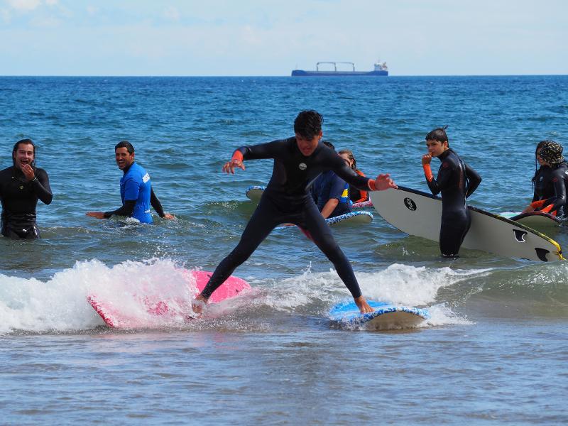 Chico surfeando en dos tablas de surf a la vez en la colonia náutica
