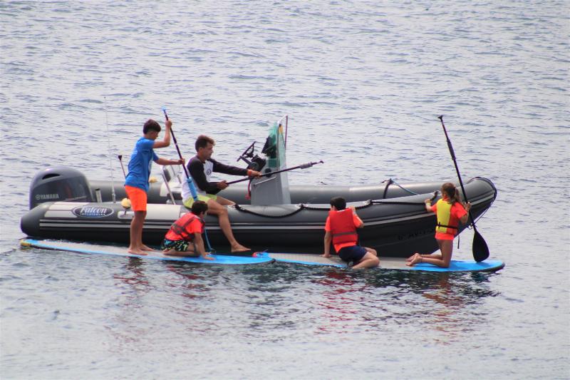Monitor enseñando a los participantes del campamento de verano Asturias cómo hacer paddle surf