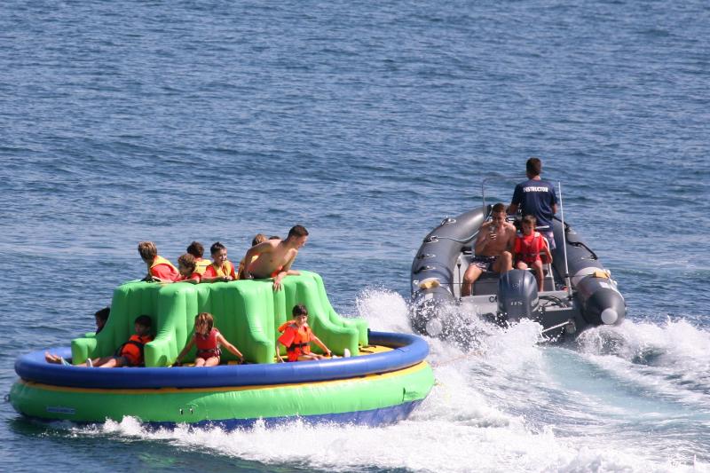 Jóvenes del campamento de verano en asturias siendo remolcados en un hinchable