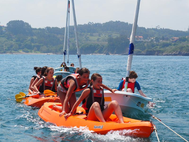 Participantes del campamento asturias navegando en pequeñas embarcaciones y kayaks