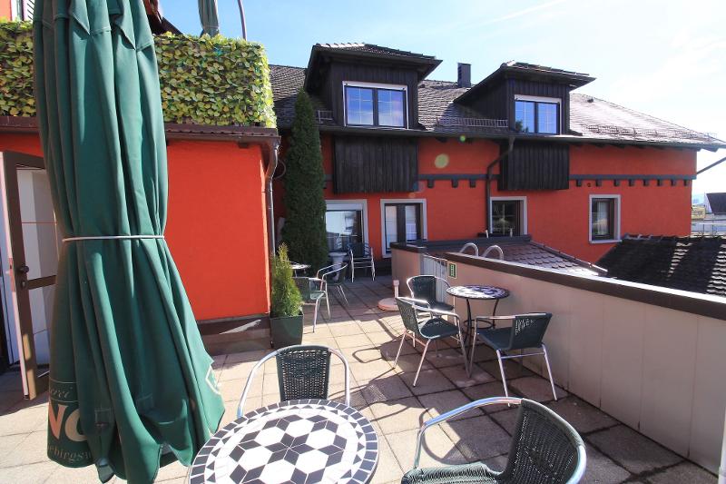 Terraza de la residencia con mesas y sombrillas para el sol del curso de verano en alemania 