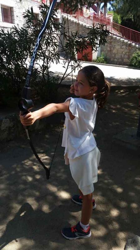 Niña practicando tiro con arco en las actividades del campamento de inglés en Madrid