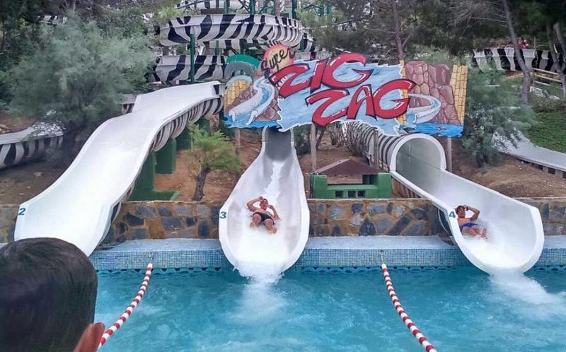 Jóvenes tirándose en tobogán en la excursión al parque acuático del campamento de verano en Valencia