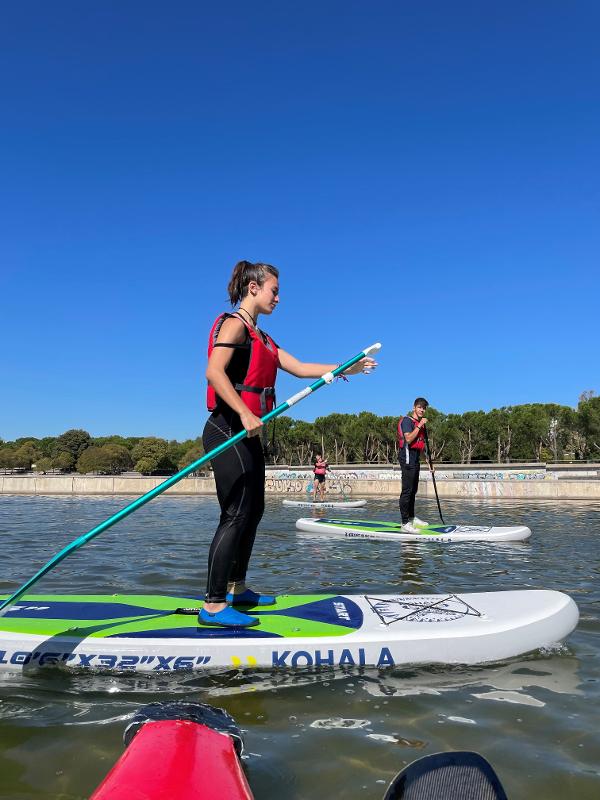 Chica haciendo paddle surf en el campamento de verano en la comunidad de madrid