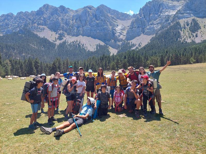 un grupo de personas en una montaña en un campamento naturaleza para niños