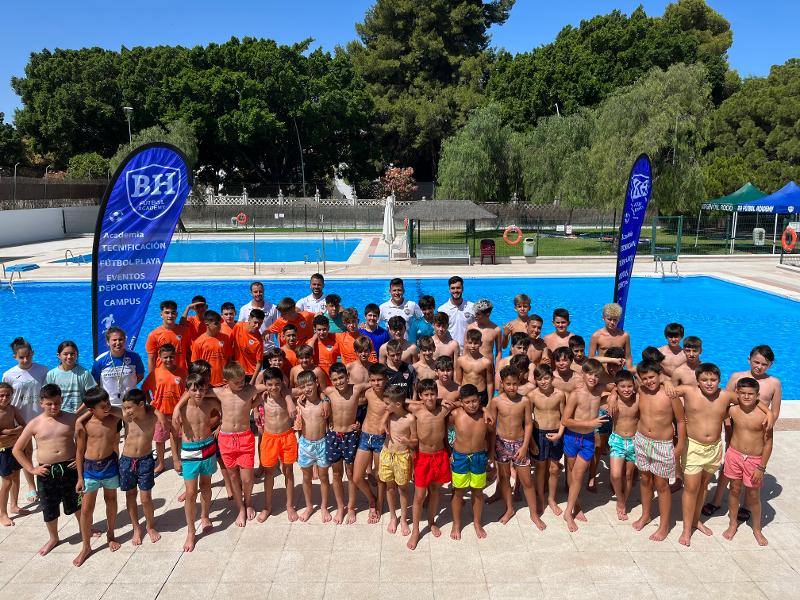 Un grupo de niños y jóvenes en una piscina en un campamentos infantiles sevilla