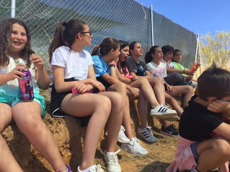 Un grupo de niños sentados en un muro en un campamento de idiomas en ciudad real