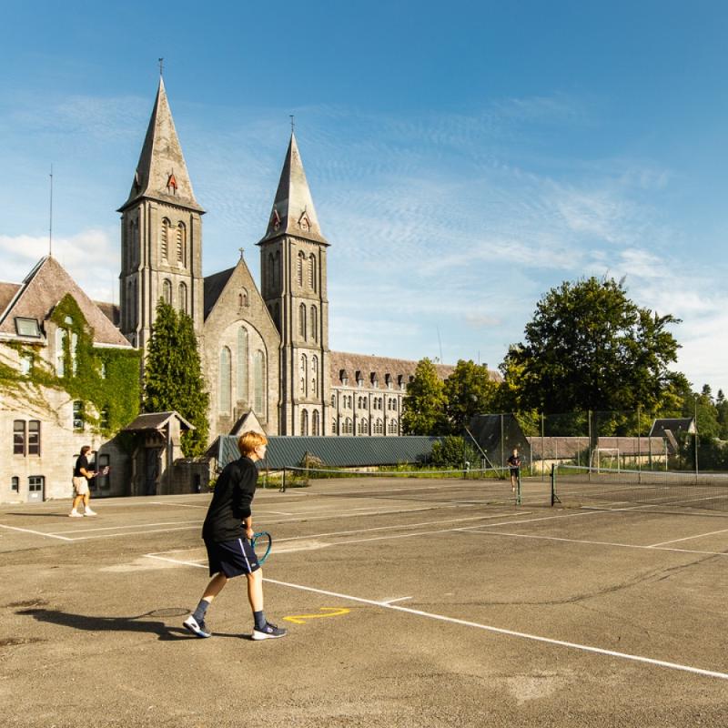Niños jugando al tenis en campamento de verano en Bélgica