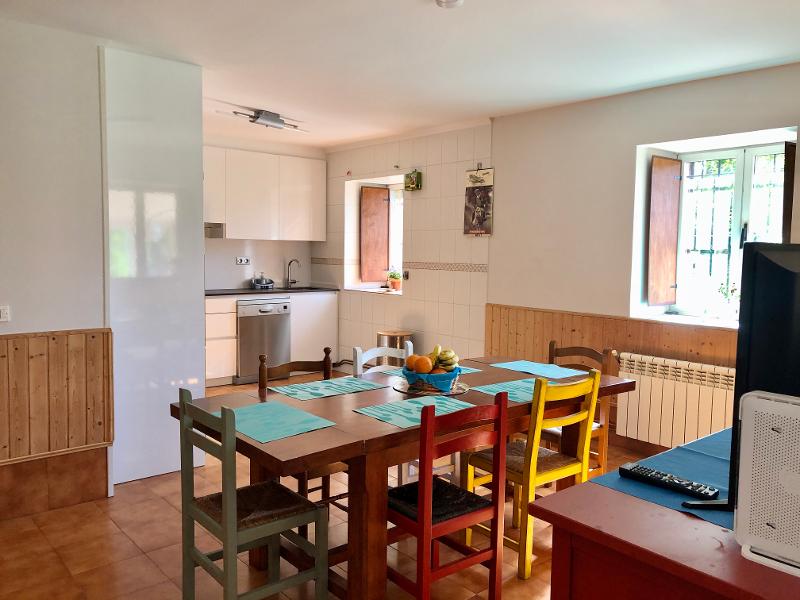 Mesa de comedor con sillas de colores en el surf hostel del campamento en Cantabria