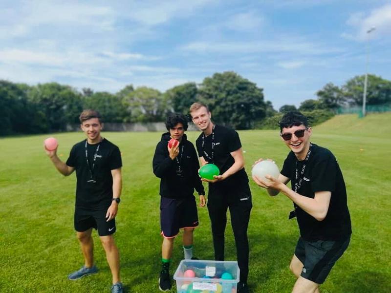 Jóvenes divirtiéndose con globos de agua en los cursos de idiomas en dublin 