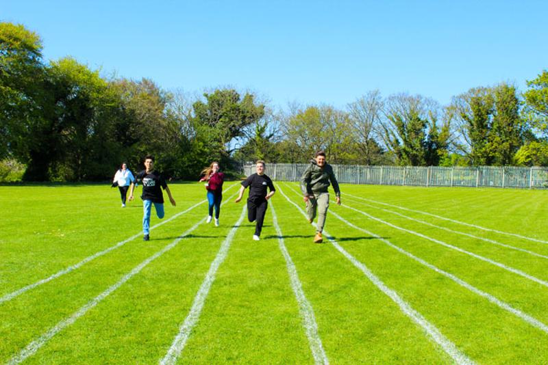 Grupo de chicos corriendo en la pista de atletismo en el curso de ingles en dublin  