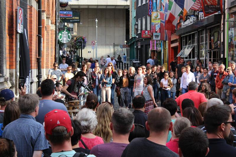 Grupo de gente viendo tocar a un músico callejero en el curso de ingles en dublin 