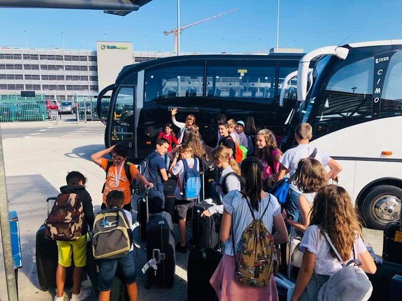 Grupo de jovenes esperando con las maletas a subir al autobús rumbo al curso de ingles en irlanda 