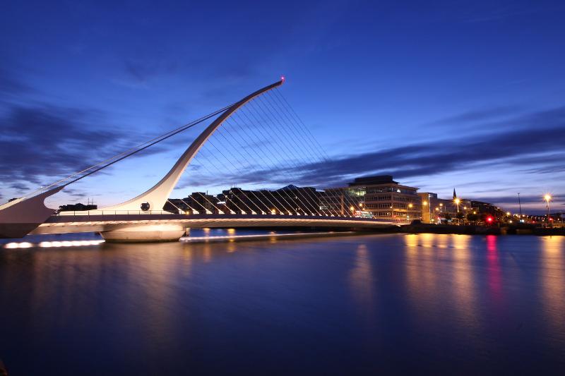Puente moderno iluminado sobre un río por la noche en el curso de ingles en irlanda en verano