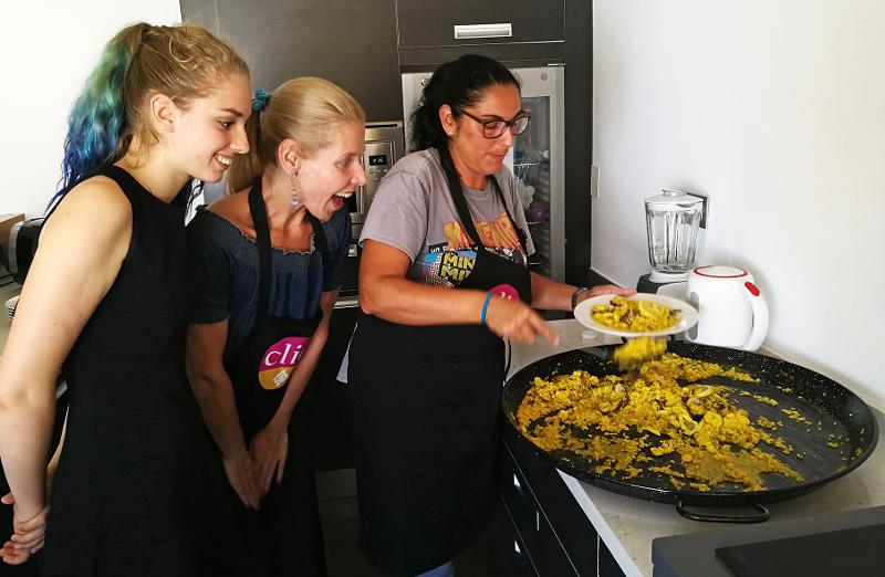 Estudiantes cocinando paella en el curso de español en españa