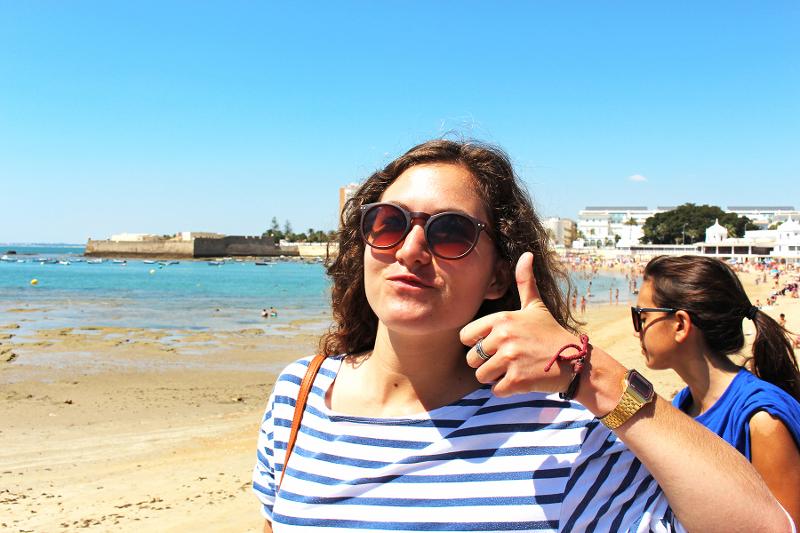 Chica poniendo morritos en la playa en el curso de español en españa