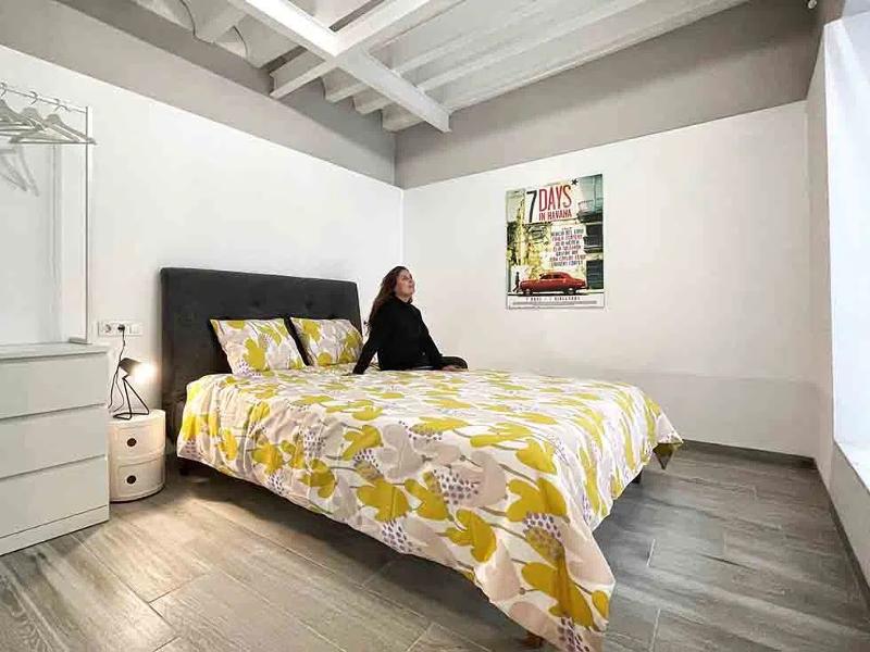 Estudiante sentada en la cama de la habitación de la residencia estudiantil  en el curso de español en españa