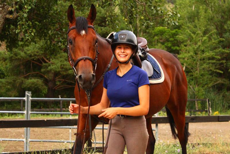 Participante del campamento equitación verano preparando a su caballo para una sesión intensiva de galopes