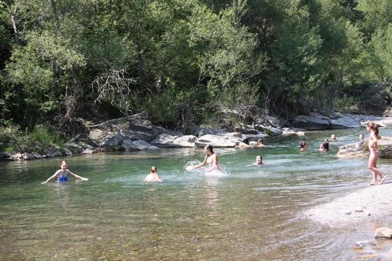 Niños bañándose en un lago en los Pirineos durante un campamento con traslado Madrid