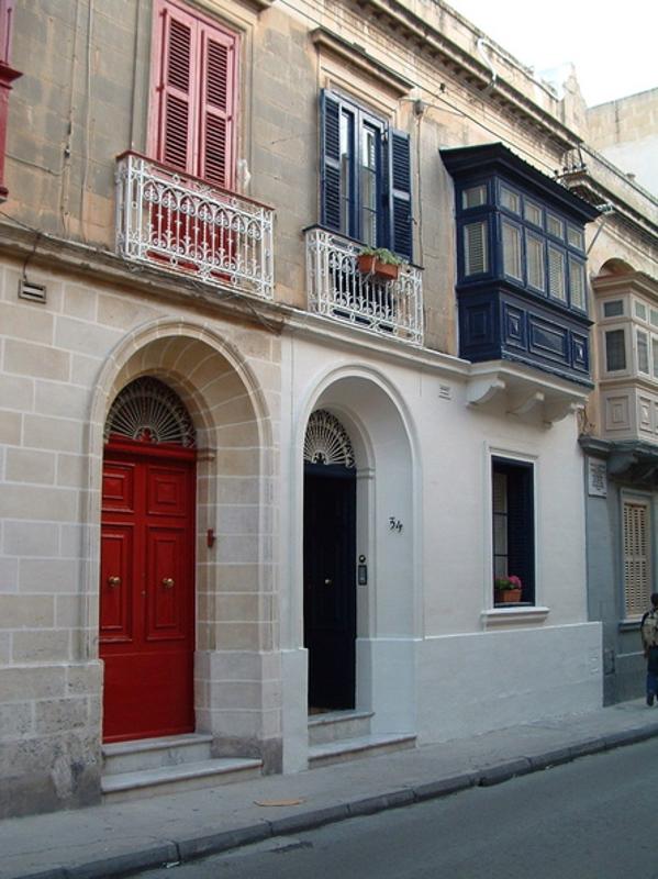 Fachada de una casa con las puertas y ventanas de colores en el curso ingles en malta 